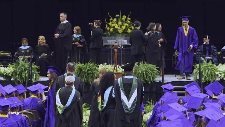 HHS graduation stage, a graduate walks towards the stairs 